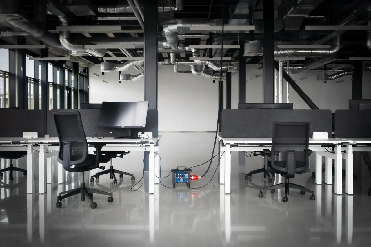 Sol en résine brillante d'un open space de bureaux vide à l'éclairage naturel