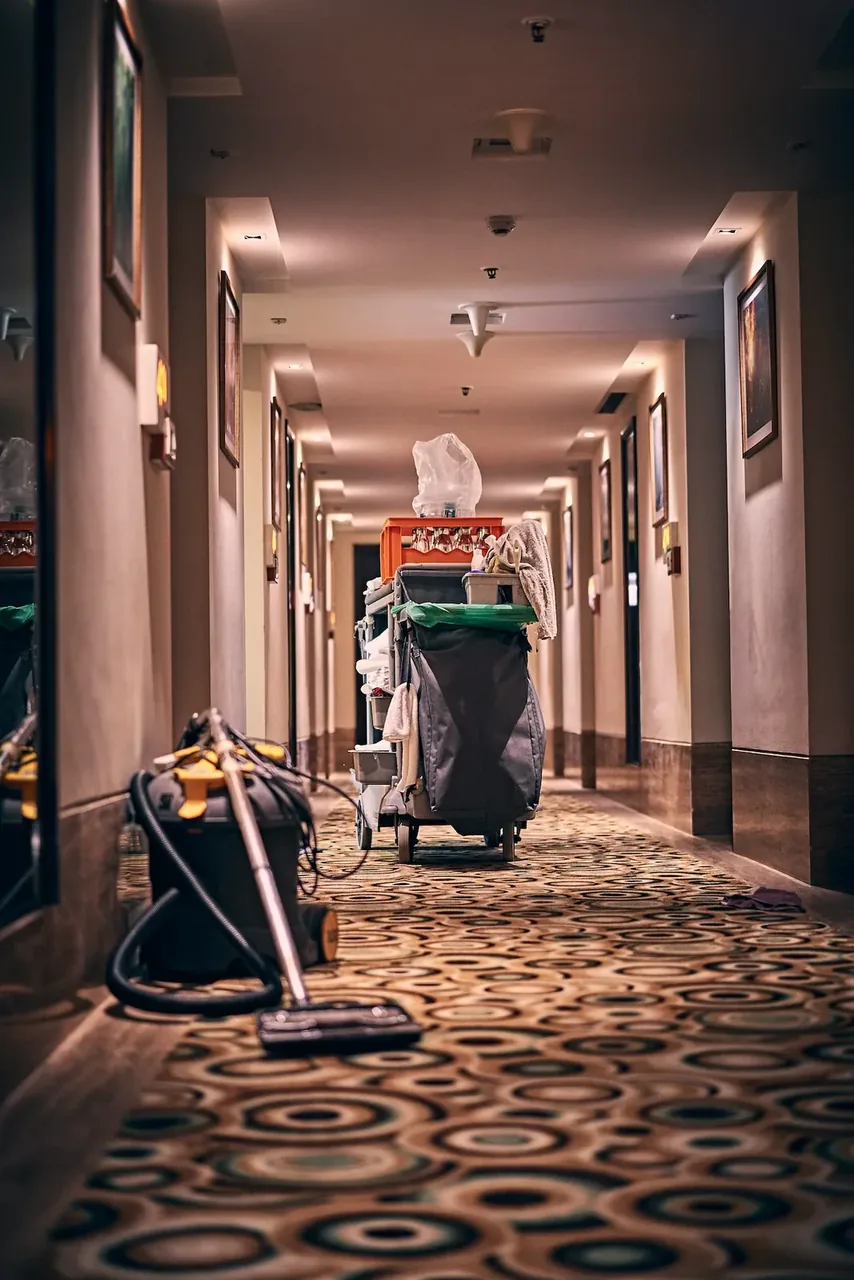 Chariot de ménage et aspirateur dans le couloir moquetté d'un hôtel