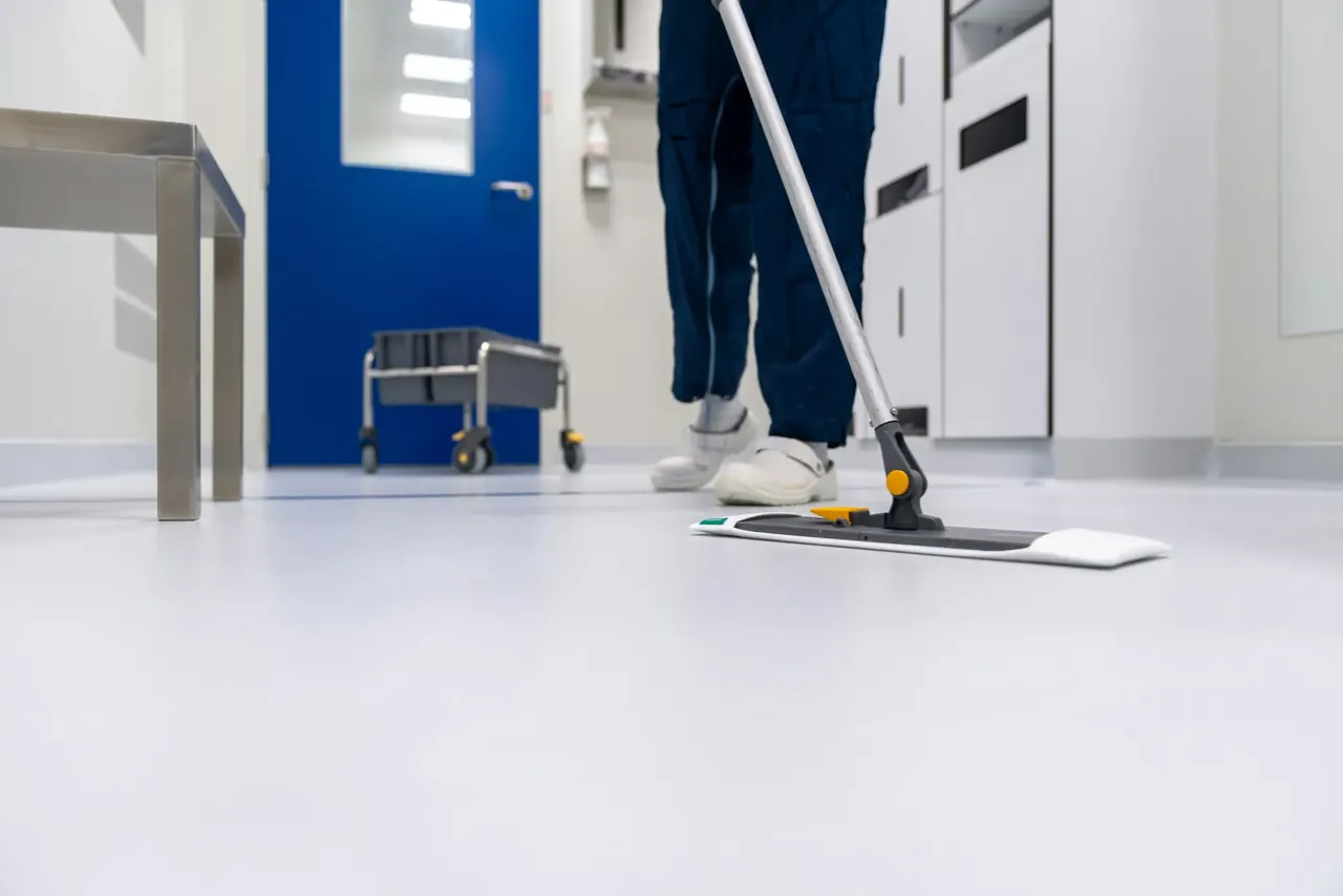 Nettoyage d'un sol en résine clair au balai microfibre dans une salle blanche