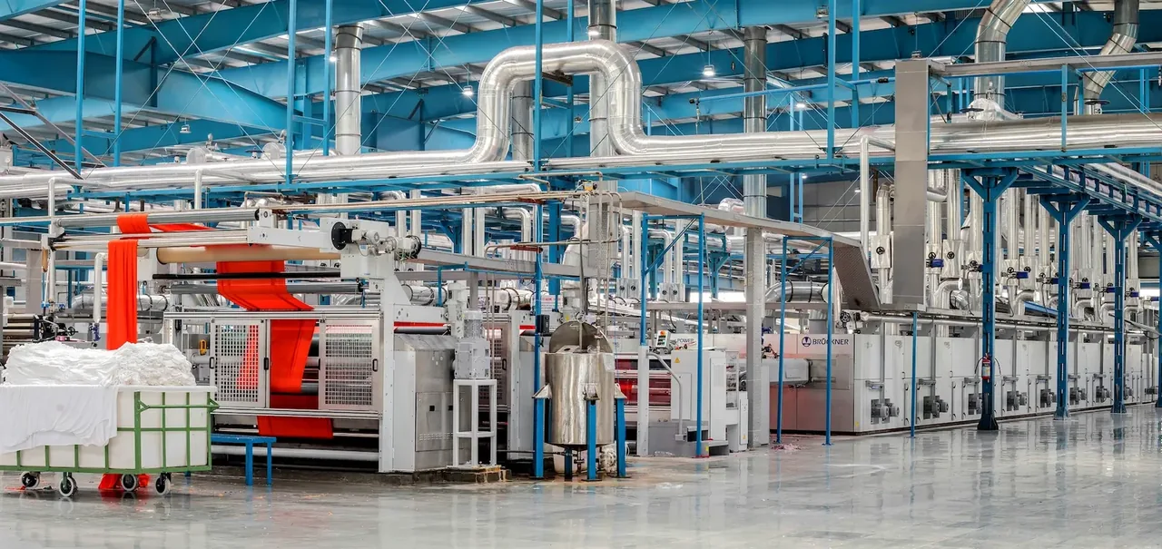 Sol clair d'une usine textile avec lignes de production et gaines techniques
