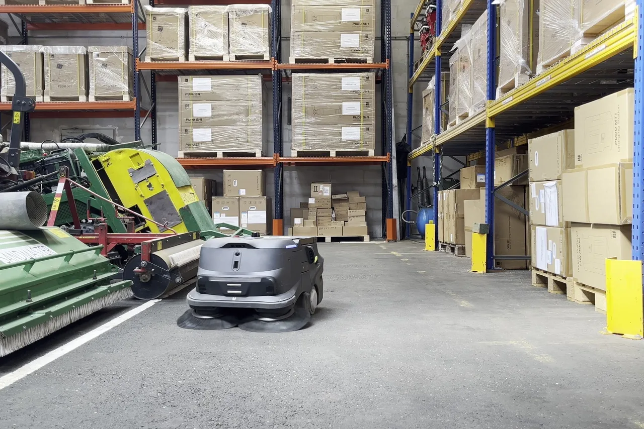 Allée principale d'un entrepôt logistique avec racks de stockage et sol en béton