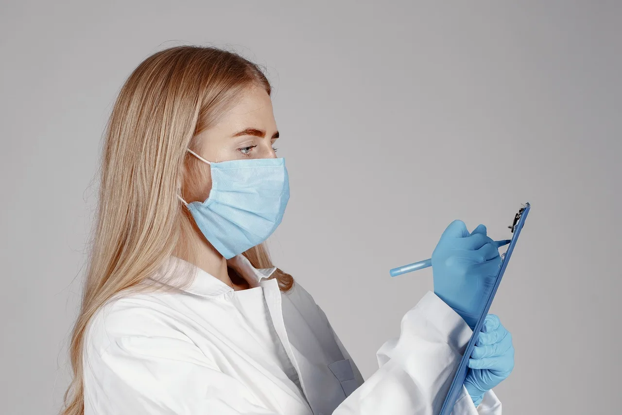 Opérateur en tenue de salle blanche dans un couloir de production pharmaceutique