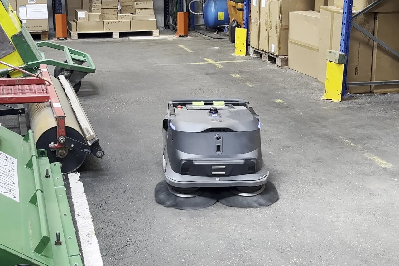 Allée de circulation entre deux lignes de production dans une usine, sol en béton
