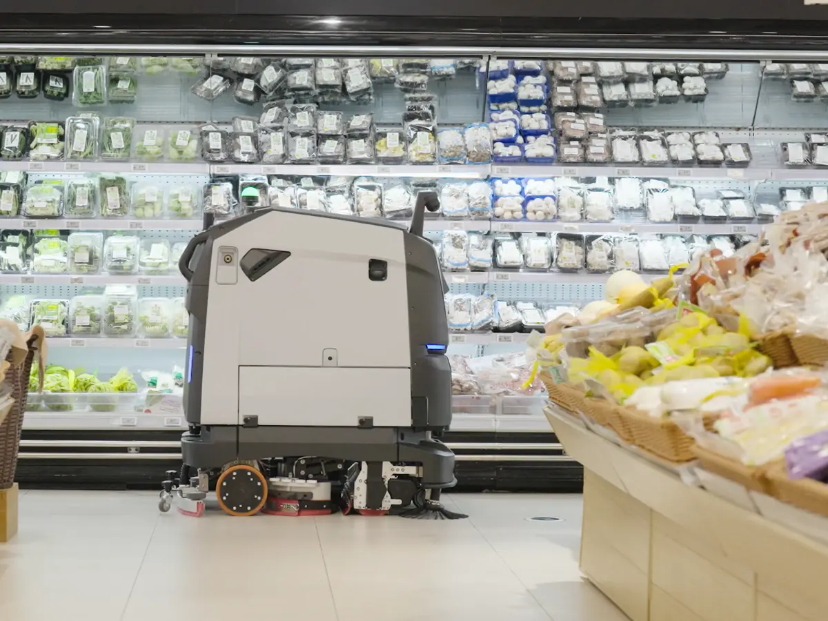 Le PUDU BG1 lave une allée de supermarché entre les étals