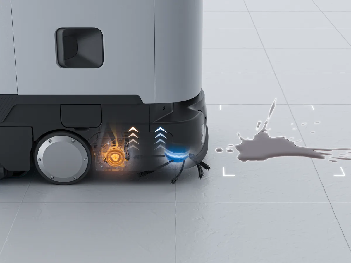 The PUDU ET1 lifting its sweeping brush in front of a spilled liquid