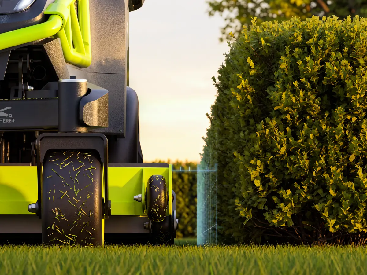 The PUDU GT5 mowing close to a hedge