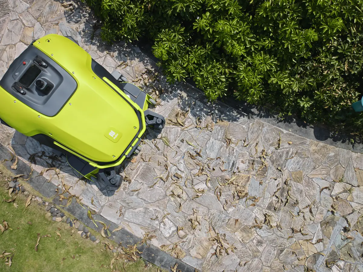 The PUDU GT5 collecting fallen leaves on a path