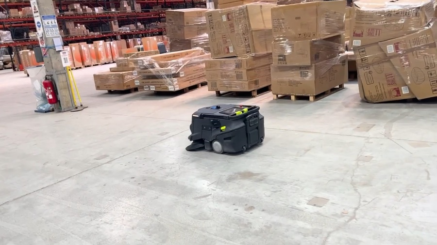 Robot de nettoyage dans une allée d'entrepôt